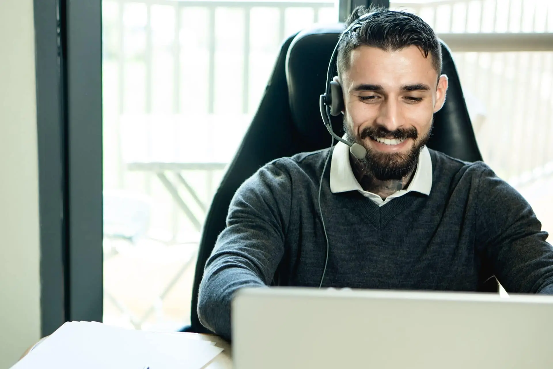 Persona brindando soporte amable con auriculares y notebook